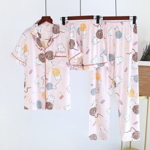 Pyjama rose trois pièces avec imprimé fils à tricoter pour femme suspendue avec un fond blanc
