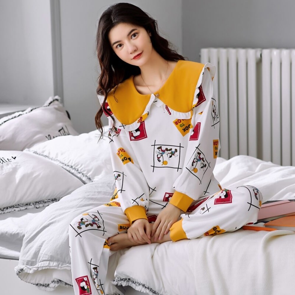 Pyjama à revers en coton manches longues pour femmes très haute qualité porté par une femme assise sur un lit dans une maison