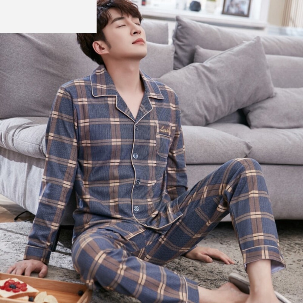 Pyjama carreaux en coton pour homme très tendance porté par un homme assis sur un tapis dans une maison