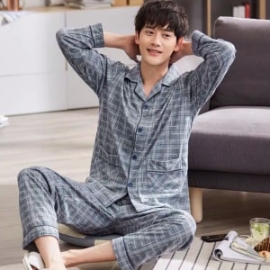 Pyjama gris à col rabattu avec imprimé géométrique pour hommes porté par un homme assis sur un tapis dans une maison