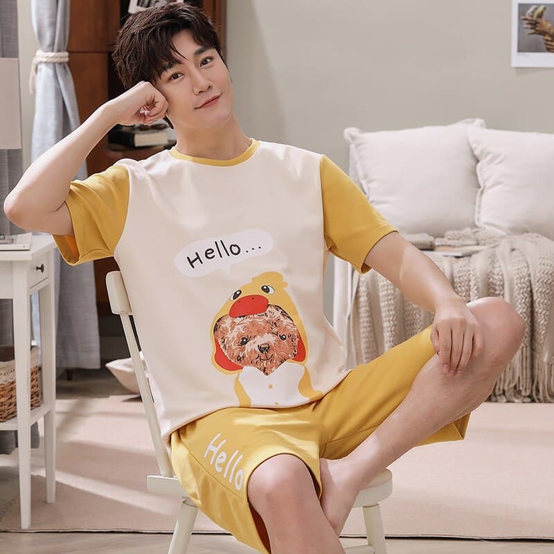 Pyjama d’été t-shirt et short en coton avec imprimé chien porté par un homme assis sur une chaise dans une maison