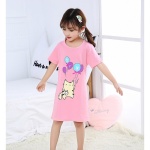 Pyjama robe de nuit en coton avec imprimé chat porté par une petite fille sur un lit dans une maison