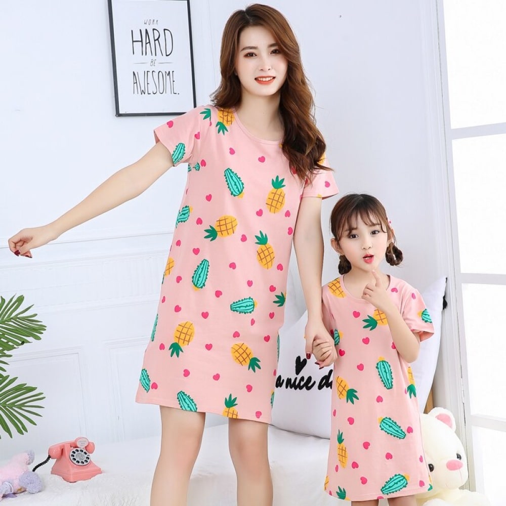 Pyjama robe de nuit rose avec imprimé ananas et cactus rose complet pour mère et fille porté par une femme et une petite fille dans une maison