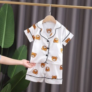 Pyjama d’été blanc en coton motif ours pour enfants sur une ceintre dans une maison