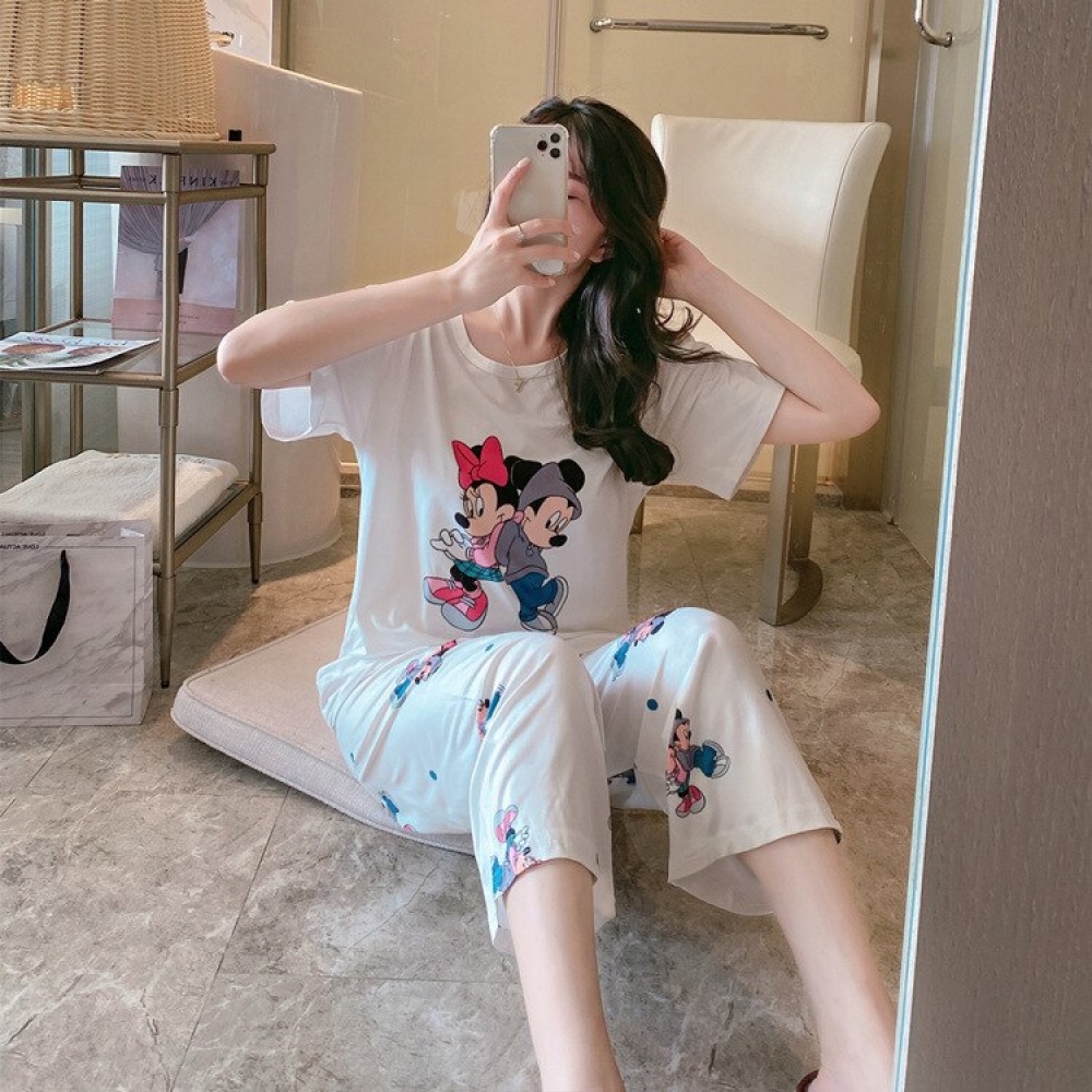Pyjama deux pièces blanc à motif Minnie et Mickey blanc porté par une femme dans une maison