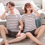 Pyjama deux pièces t-shirt blanc rayé marron et short marron très à la mode , porté par un couple dans une maison