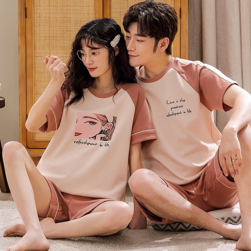 Pyjama deux pièces en coton t-shirt blanc rose et short rose porté par une couple assise sur un tapis dans une maison