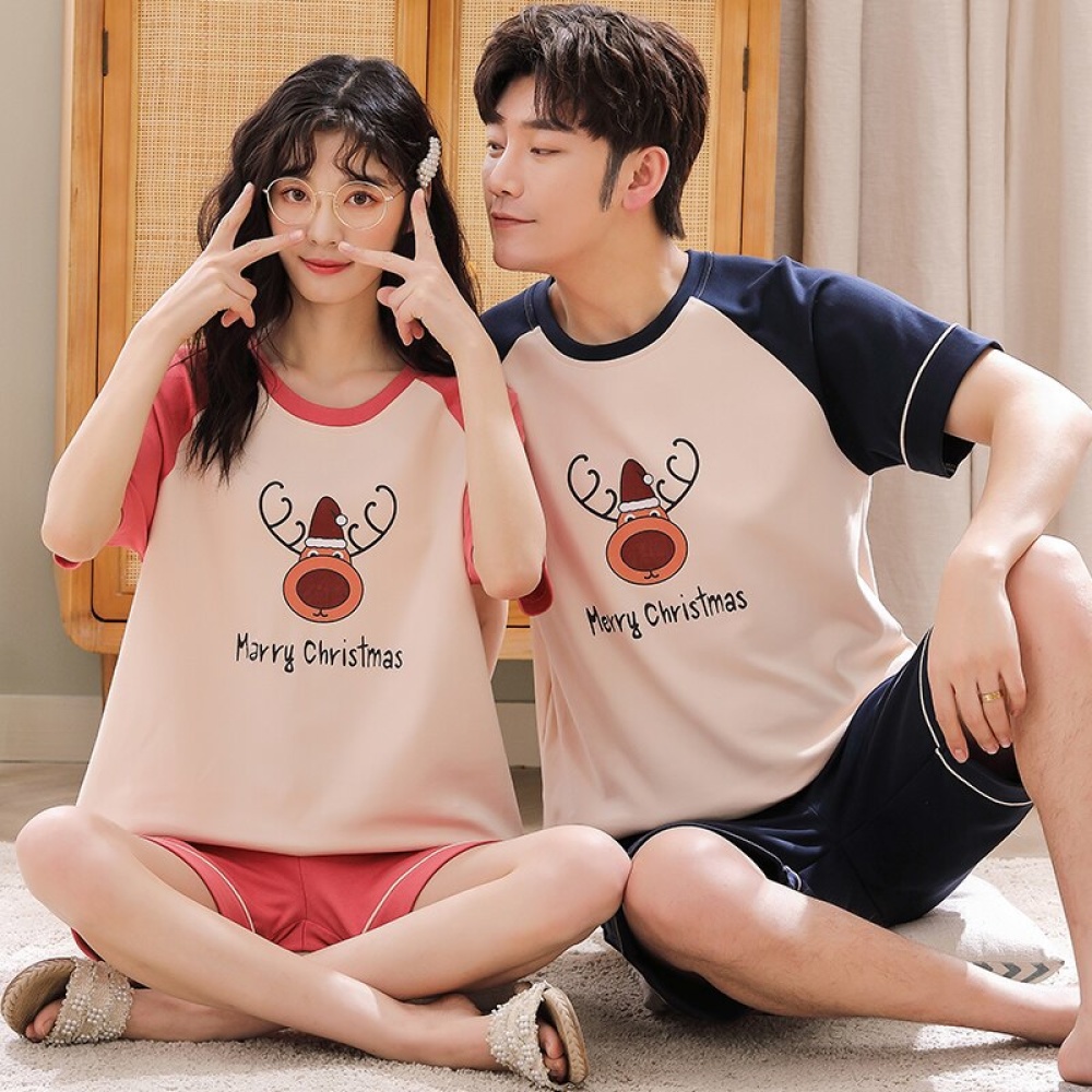 Pyjama deux pièces en coton t-shirt renne de père noël et short portés par une couple assise sur un tapis dans une maison