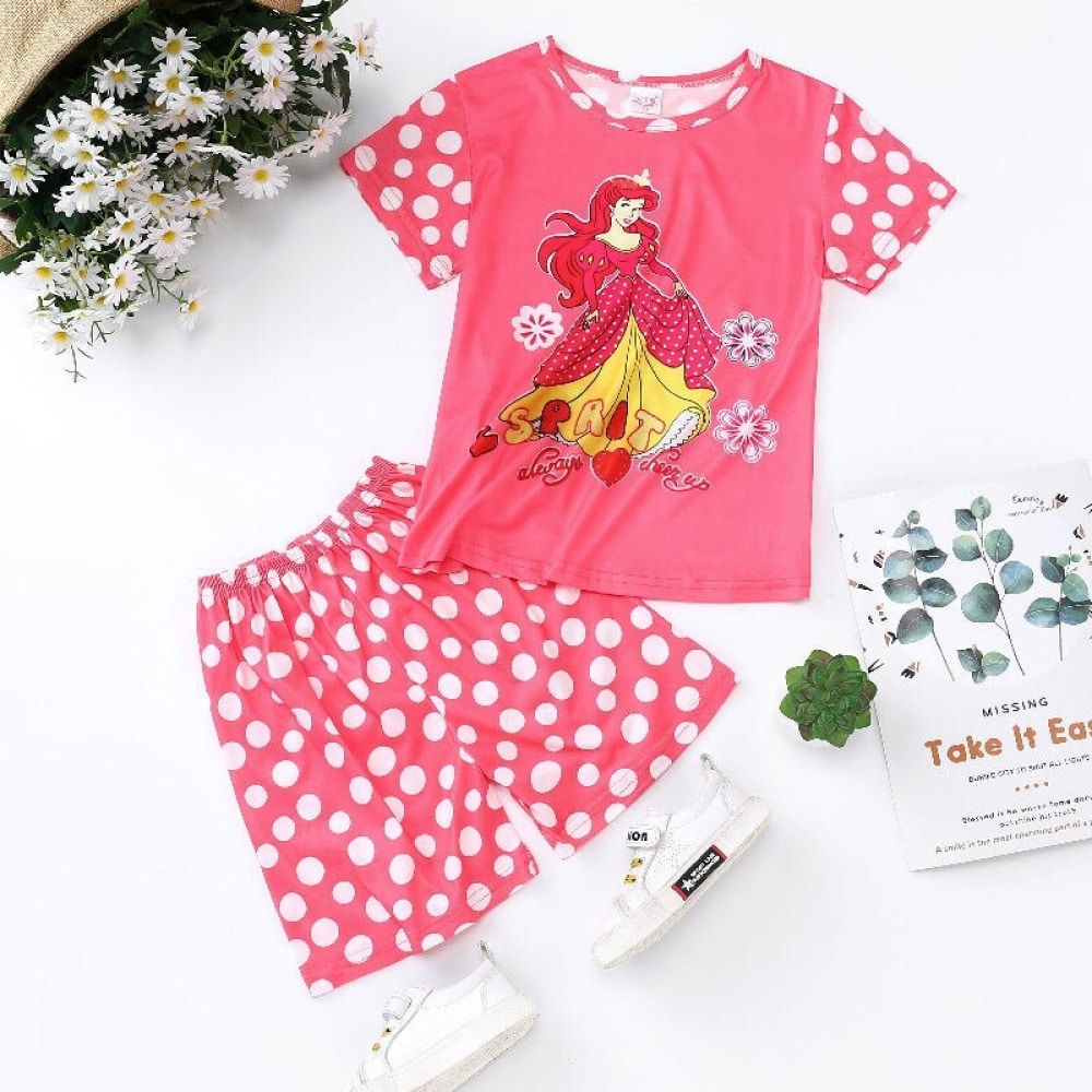 Pyjama deux pièces roses motif princesse pour fille avec un magasine à coté