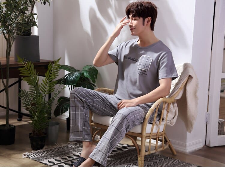 Pyjama courtes manches à carreaux pour homme porté par un homme assise sur une chaise dans une maison