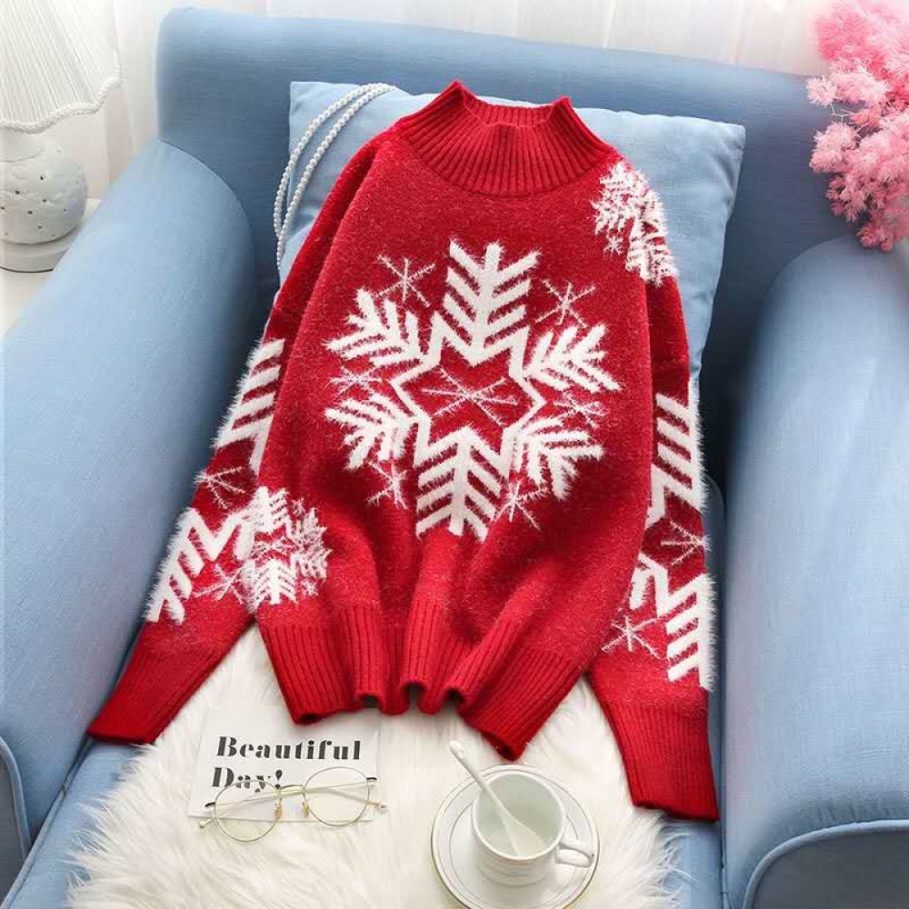Pull de Noël tricoté avec flocon de neige pour femme blanc et rouge sur une chaise dans une maison