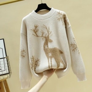 Pull en laine tricoté pour femme avec renne de Noël haute qualité sur une ceintre dans une maison