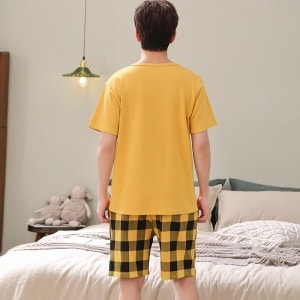 Pyjama Garfield d'été à manches courtes pour hommes jaune porté par un homme devant un lit dans une maison