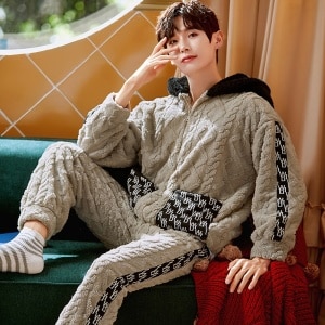 Pyjama chaud à capuche pour homme porté par un homme qui s'assoit sur une chaise dans une maison
