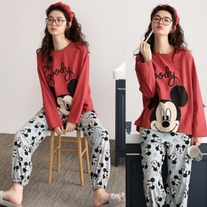 Ensemble pyjama Mickey pour femmes porté par une femme qui porte une serre tête assise sur une chaise dans une maison