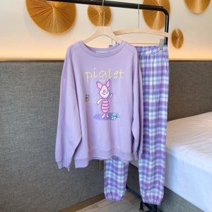 Pyjama Porcinet avec pantalon à carreaux pour femme violet sur une ceintre dans une maison