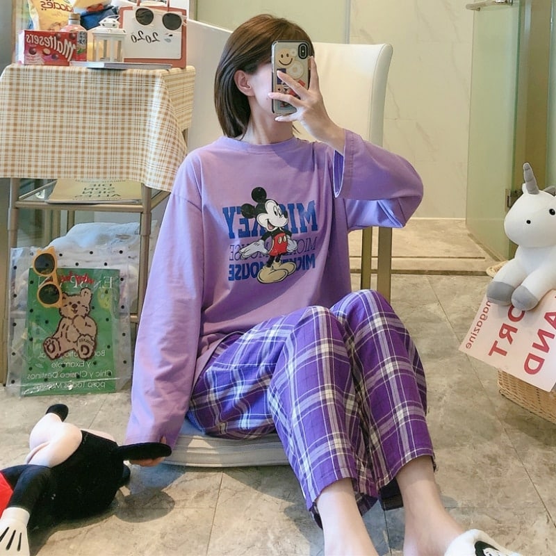 Pyjama Mickey avec pantalon à carreaux pour femme violet porté par une femme qui prend un photos dans une maison
