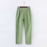 Un pantalon vert clair en coton et lin suspendu sur a cintre