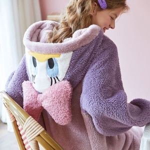 Combinaison Disney violet et rose avec une femme qui sourit et porte le pyjama