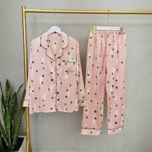 Pyjama automne deux pièces roses à manches longues pour femmes sur une ceintre dans une maison