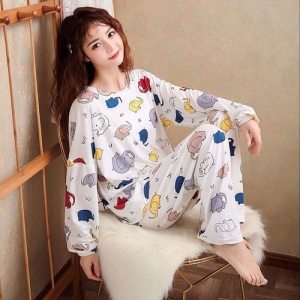 Pyjama automne manches longues à motif éléphants porté par une femme assise sur une chaise