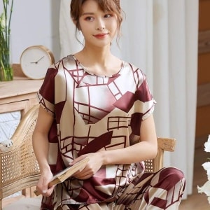 Pyjama luxe deux pièces à manches courtes pour femmes portée par une femme assise sur une chaise dans une maison