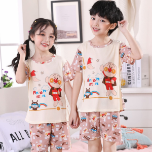 Pyjama d'été à motif dessin animé pour enfant porté par un petit garcon et une petite fille à l'intérieur d'une maison avec un cadre accroché au mur