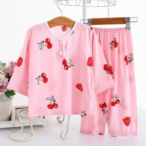 Pyjama en coton à manches mi-longues motif fraise et cerise rose sur une ceintre dans une maison