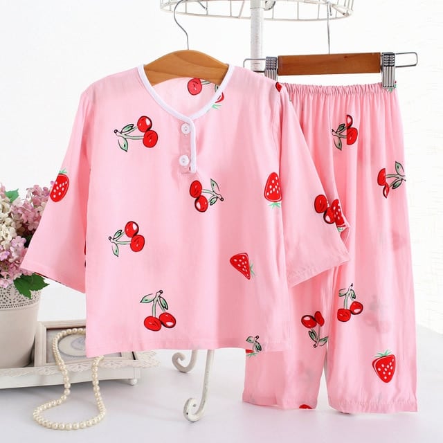Pyjama en coton à manches mi-longues motif fraise et cerise rose sur une ceintre dans une maison