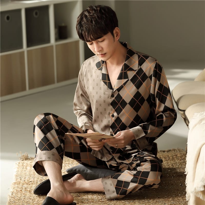 Pyjama en coton à manches longues avec col rabattu pour homme porté par un homme assise sur un tapis dans une chambre à coucher