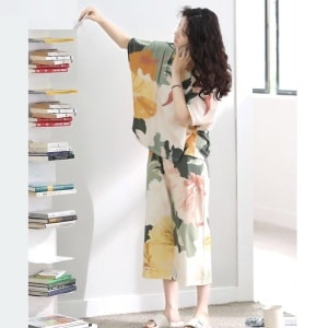 Pyjama d'été à manche chauve-souris avec imprimé floral portée par une femme qui prend un livre dans une maison