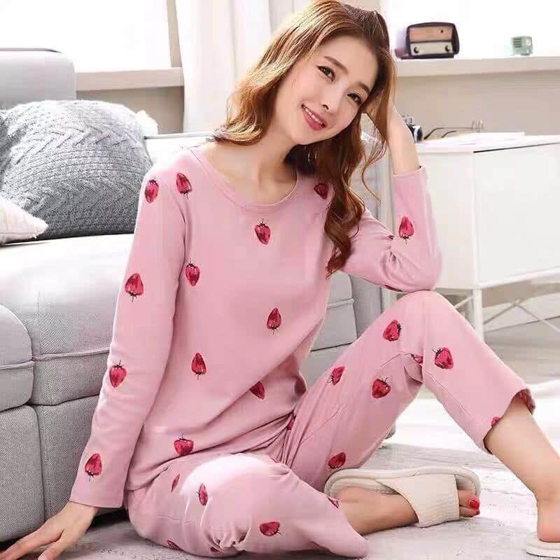 Pyjama rose à manches longues et motif fraises pour femmes porté par une femme dans une maison