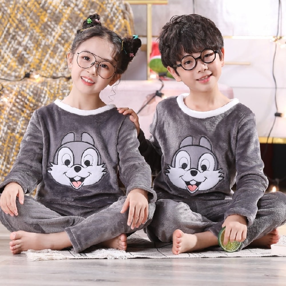 Pyjama en flanelle à motif lapin Panpan pour enfant porté par un petit garçon et une petite fille assise sur tapis devant une table de nuit dans une maison