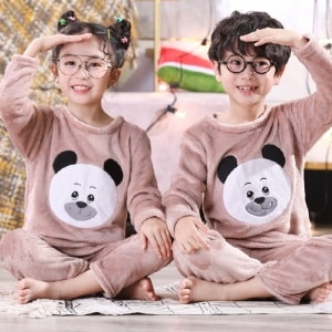 Pyjama en flanelle à manches longues avec imprimé panda pour enfant porté par un petit garcon et une petite fille assise sur un tapis dans une maison