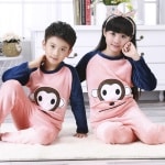 Pyjama en flanelle avec imprimé singe pour enfant porté par un petit garcon et une petite fille assise sur un tapis dans une maison