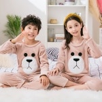 Pyjama marron en flanelle polaire pour enfant porté par une petite fille et un petit garçon assise sur un tapis dans une maison