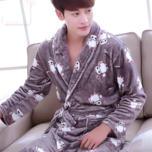 Pyjama Kimono en flanelle à motif Baymax de nouveaux héros pour homme porté par un homme assise sur un canapé dans une maison