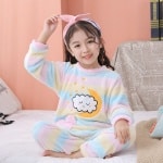 Pyjama polaire coloré pour enfants arc-en-ciel porté par une petite fille sur un lit dans une maison