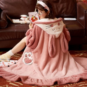 Pyjama polaire long à capuche lapin pour femmes rose avec un fond un canapé