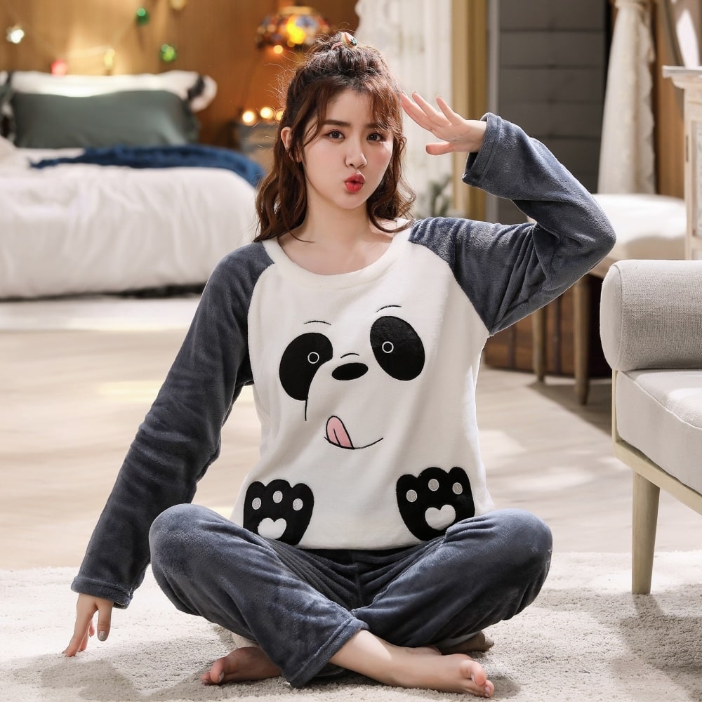 Pyjama polaire avec une tête de Panda unisexe bleu et blanc porté par une jeune femme souriante