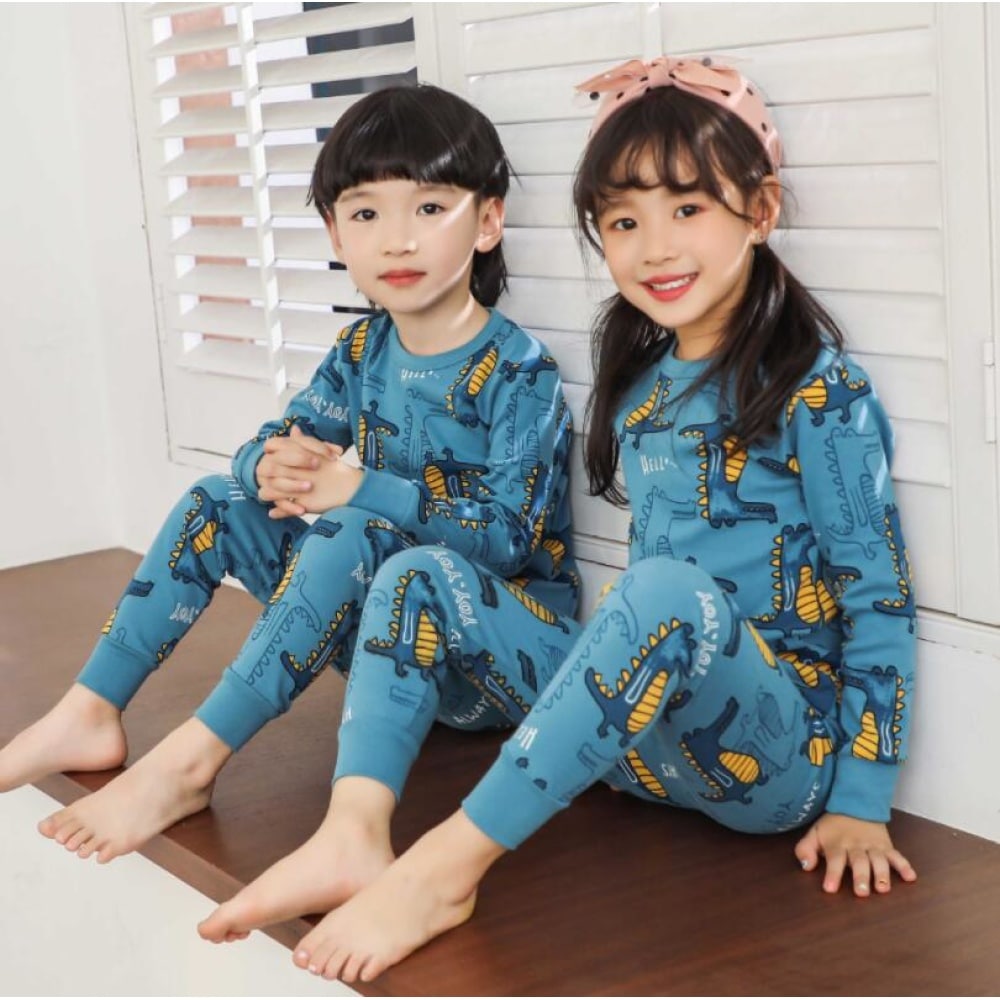 Pyjama printemps bleu à motif dinosaure pour enfants avec deux enfants qui porte le pyjama