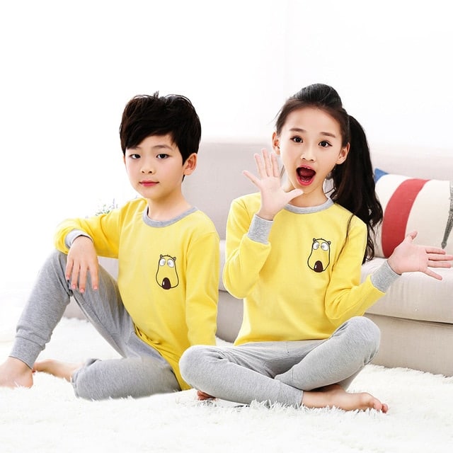 Pyjama printemps avec pull jaune et pantalon gris pour enfants avec deux enfants qui porte le pyjama