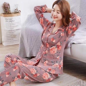 Pyjama en coton deux pièces à motif floral pour femmes, portée par une femme assise sur un tapis dans une maison