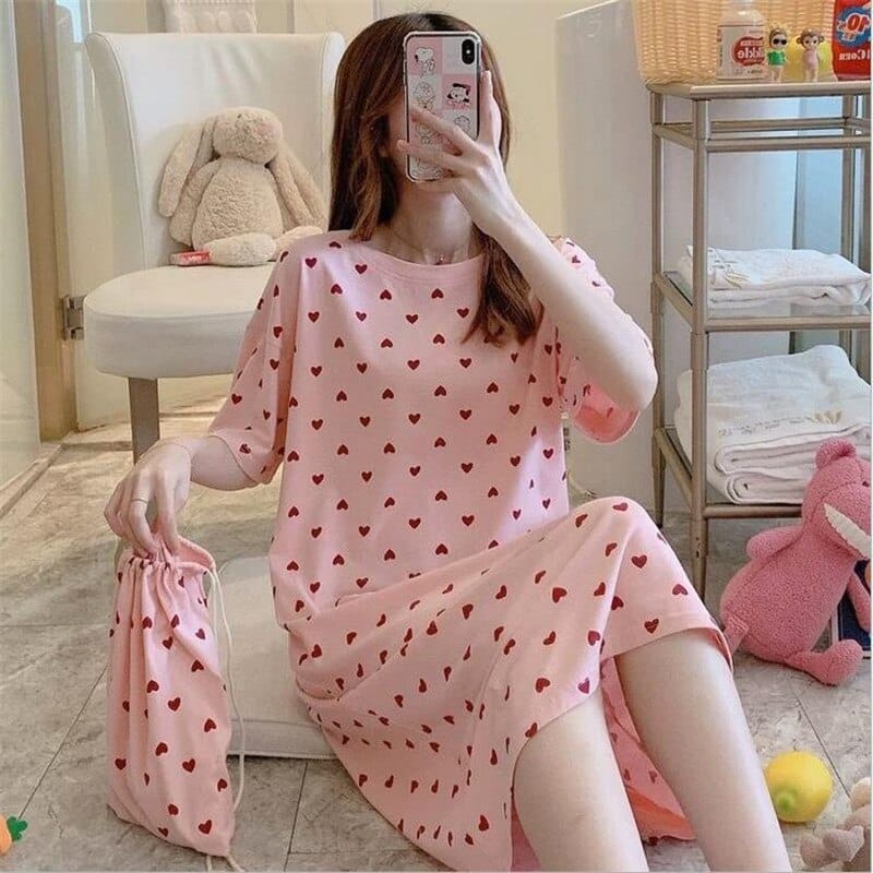 Pyjama robe de nuit à manches courtes avec imprimé cœur porté par une femme assise sur un tapis dans une maison