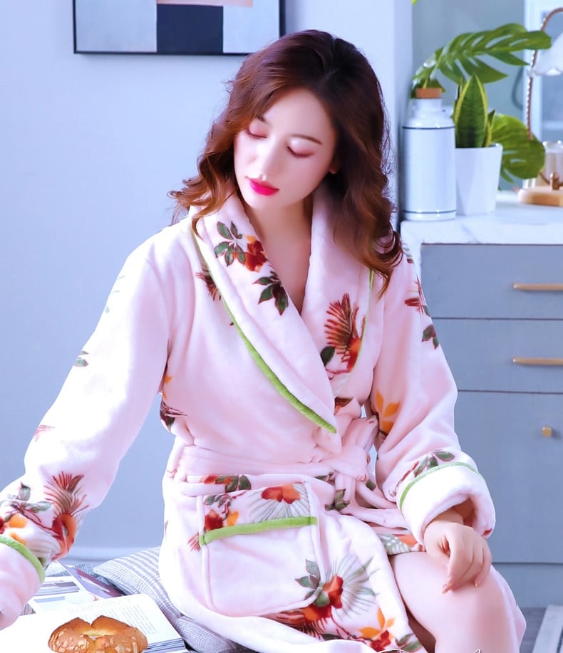 Pyjama peignoir en molleton avec imprimé floral pour femmes très haute qualité portée par une femme assise sur un lit dans une maison