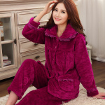 Pyjama épais en polaire couleur unie pour femme à la mode portée par une femme assise sur un tapis dans une maison